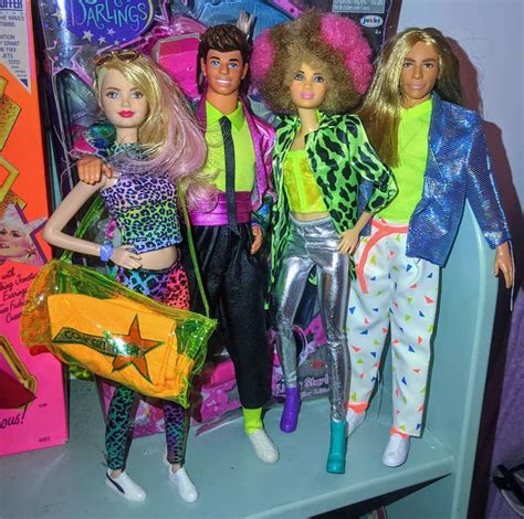 four barbie dolls are posed next to each other