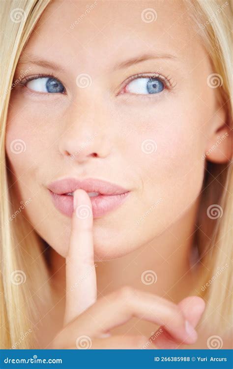 Her Lips Are Sealed Portrait Of A Young Woman Holding Her Finger In Front Of Her Lips Stock