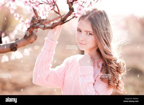 Beautiful Blonde Teenage Girl 14 16 Year Old Holding Peach Tree In Garden Posing Outdoors