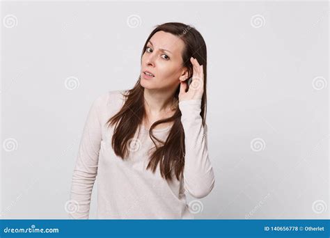 Portrait Of Concerned Young Woman In Light Clothes Looking Camera And