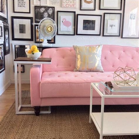 A Living Room With Pink Couches And Pictures On The Wall Above It