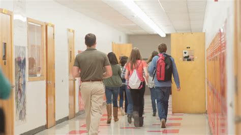 A Busy School Hallway With Students Walking To And From Class Stock