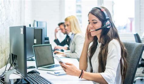 Friendly Female Customer Support Operator With Headset Using Phone In