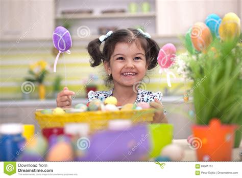 Cute Little Girl With Basket Full Of Colorful Easter Eggs Stock Image