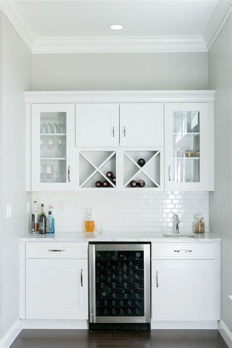 This kitchen features ikea cabinet bases with semihandmade fronts painted dunn edwards white. White, window-front cabinets create a bigger feel in this custom wet bar. #bardecorforhome ...