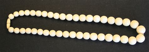 A Single Row Necklace Of Graduated Spherical Ivory Beads