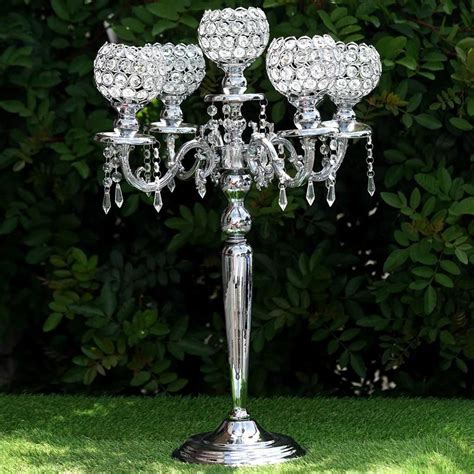 A Metal Candelabra Sitting On Top Of A Lush Green Field