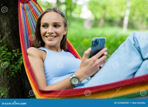 Young Woman Chilling In Hammock And Holding Phone Girl With Phone