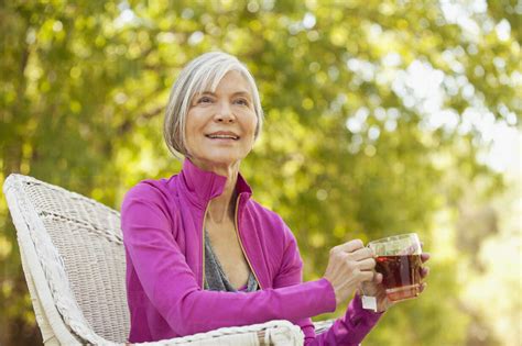 Older Woman Drinking Tea Outdoors Stock Photo