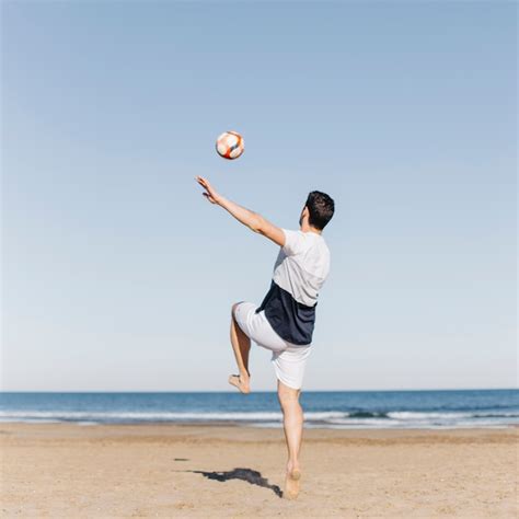 Jeune Homme Jouant Au Football La Plage Photo Gratuite