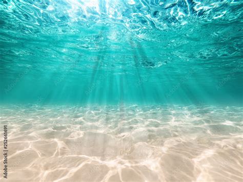 Underwater Background Deep Blue Sea And Beautiful Light Rays With Sandy Floor Stock Photo