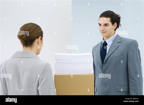 Young Professionals Standing Face To Face Documents Stacked On