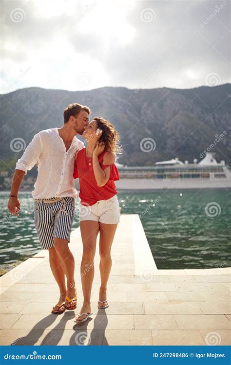 Walking On Pier Man Kissing Woman On Cheek Couple In Love Cruiser And Mountains In Background