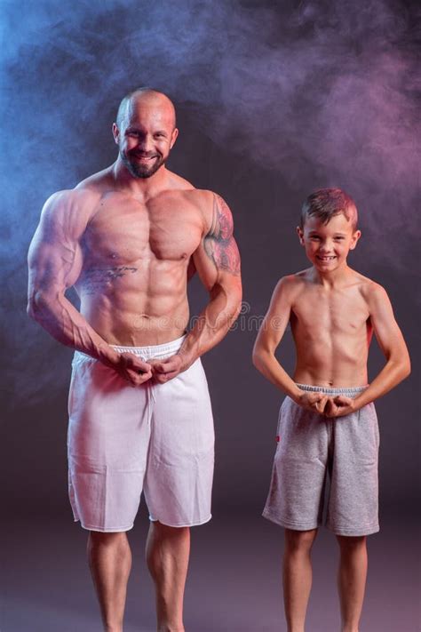 Powerful Muscular Man Shirtless Posing With His Son In The Studio With