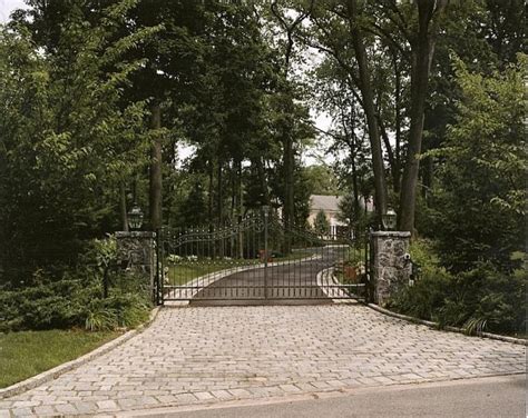 Driveway Entrance With Custom Iron Gates Stone Piers And Cobblestone