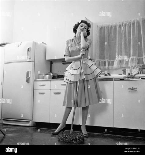1950er Jahren Gelangweilt Frau Hausfrau TrÄgt SchÜrze StÜtzte Sich Auf Mop Auf KÜchenboden