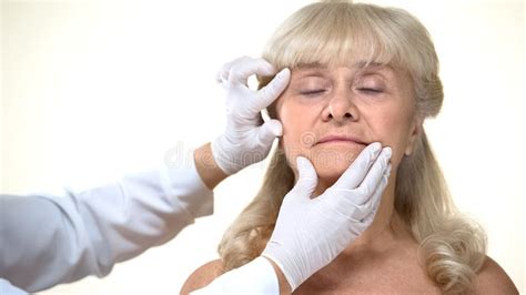 Dermatologist Examining Elderly Female Patient Skin Wrinkles Removal