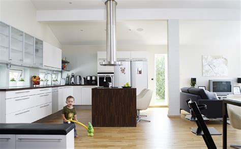 The dining room pendant lights and table legs add pops of yellow while the doorways and countertops showcase a rich green. Scandinavian Kitchens