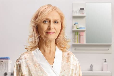 Mature Woman In A Silk Bathrobe Posing In A Bathroom Stock Photo
