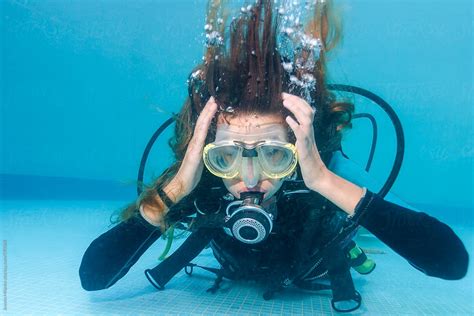 woman scuba diving holding her head as if having ear equalization problem by stocksy