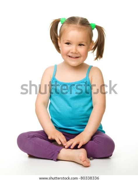 Portrait Of A Cute Little Girl Sitting On Floor Isolated Over White