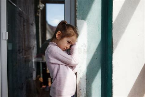 A Sad Little Girl Is Standing Near The Window Stock Image Image Of