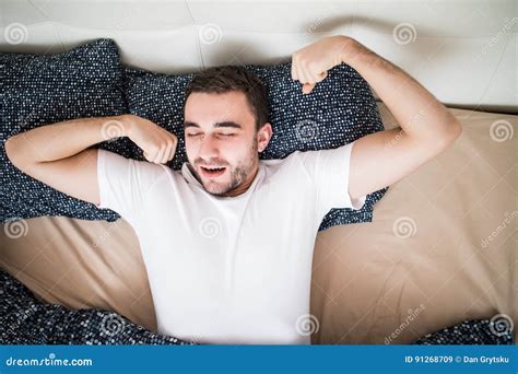 Young Handsome Happy Man Waking Up On Bed At Home Top View Stock Image