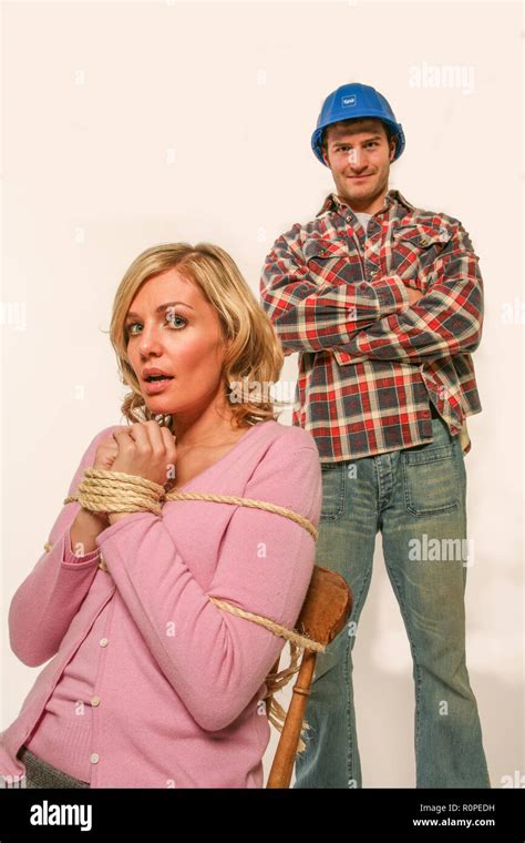 Woman Tied To A Chair By An Aggressive Builder Stock Photo Alamy