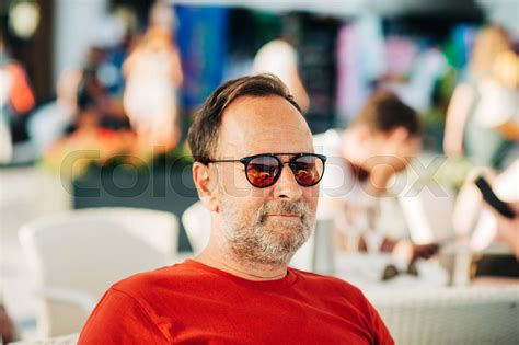 outdoor portrait of 50 year old man wearing red t shirt and sunglasses stock image colourbox