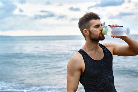 Man Drinking Refreshing Water After Workout At Beach Drink Stock Photo
