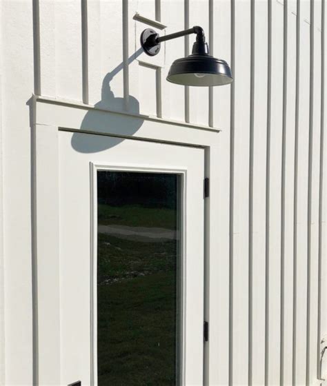 Like gooseneck barn lights, barn light sconces feature a shade with a curved arm. A gooseneck light above the door keeps this home exterior ...
