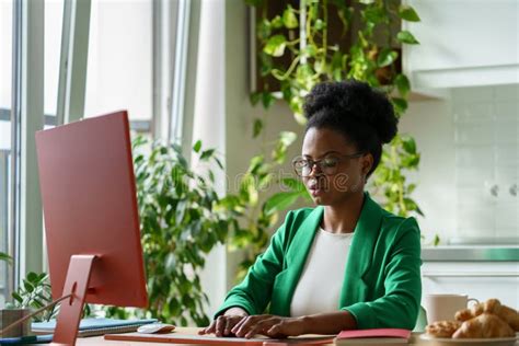 successful african american woman working as editor magazine typing article sits at computer