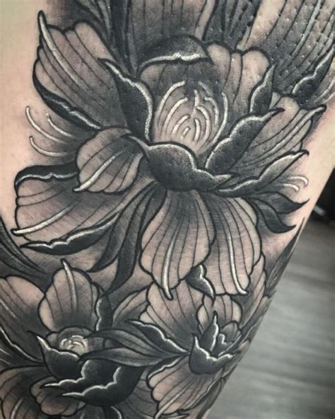 A Black And White Photo Of Flowers On The Thigh With One Flower In The