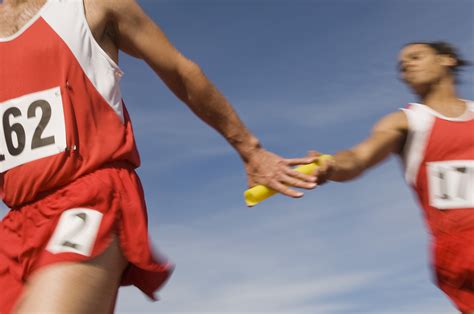 Male Athletes Passing Baton In Relay Race The Travel Vertical