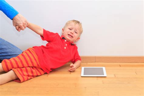Agitated Child Being Pulled Away By Parent From Ipad Stock Photo