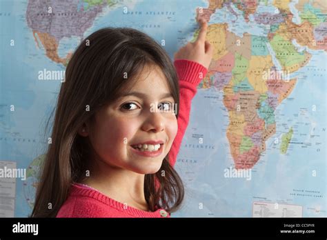 Young Girl Pointing To Different Countries On The World Map Stock Photo