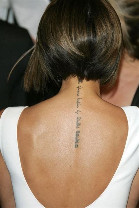 the back of a woman s neck with a tattoo on her left shoulder and words written in cursive writing