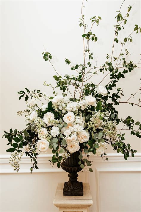 Loose And Organic Garden Urn Arrangements Of All White Roses Larkspur