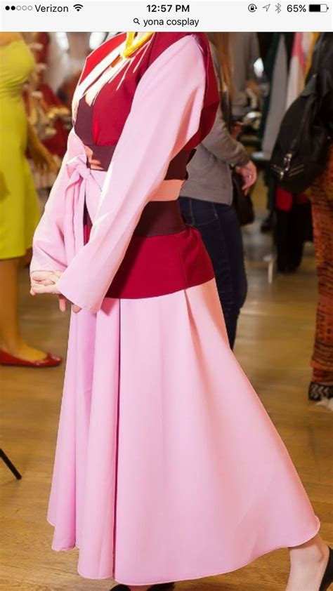 A Woman With Red Hair Wearing A Pink Dress And Black Shoes Standing In