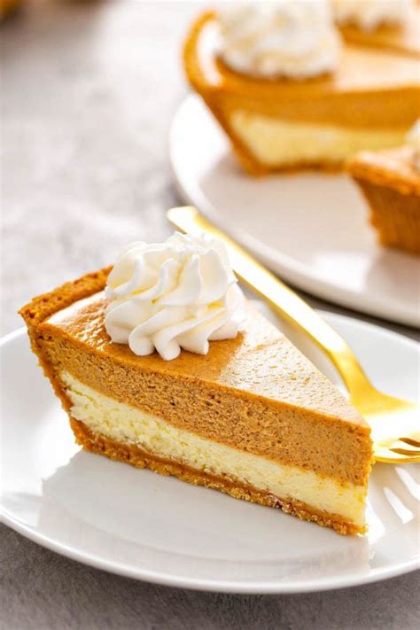 A Slice Of Pumpkin Pie Cheesecake With Whip Cream On A White Plate
