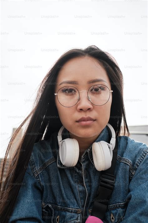 portrait of an asian girl wearing glasses and headphones looking straight at the camera photo