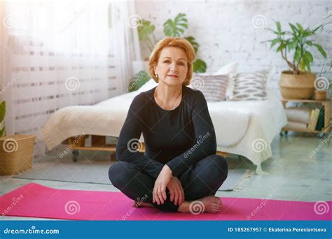 Mature Woman Doing Yoga Sitting On The Mat At Home Healthy Lifestyle