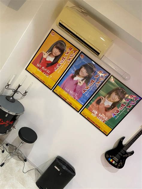 There Are Two Posters On The Wall Next To Some Drums And An Electric