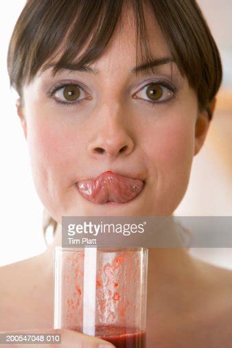 Young Woman Drinking Fruit Smoothie Licking Lip With Tongue Closeup