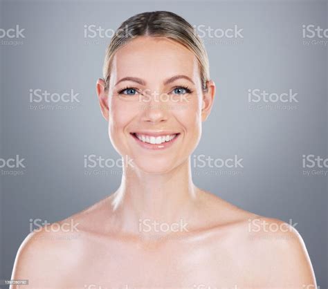 Studio Portrait Of An Attractive Mature Woman Posing Against A Grey