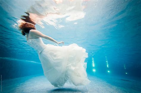 trash the dress underwater bride swimming at the surface by stocksy contributor jp danko