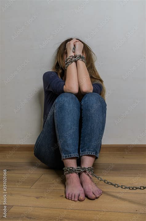 Hostage Girl Sitting On The Floor With Arms And Legs Chained In Chains Stock Photo Adobe Stock