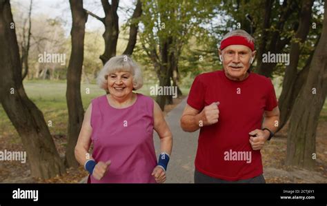 Active Senior Elderly Runner Couple 80 Years Old Caucasian Man And Woman Running In City Park