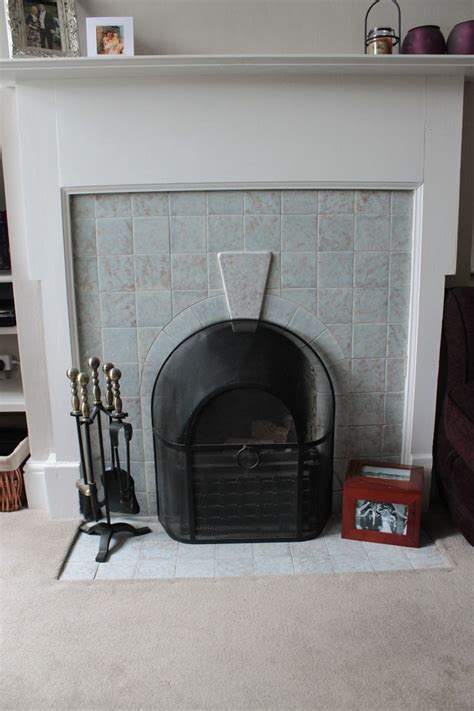 A substantial tiled fireplace with scalloped top and pattern imprinted tiles. 1930s fireplace | 1930s house | Pinterest