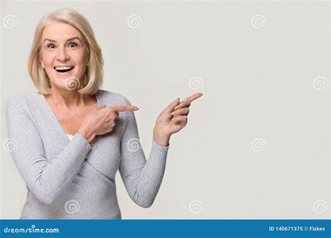 Amazed Excited Mature Woman Pointing At Copyspace Isolated On Background Stock Image Image Of
